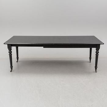 A contemporary dining table with 2 additional leaves.