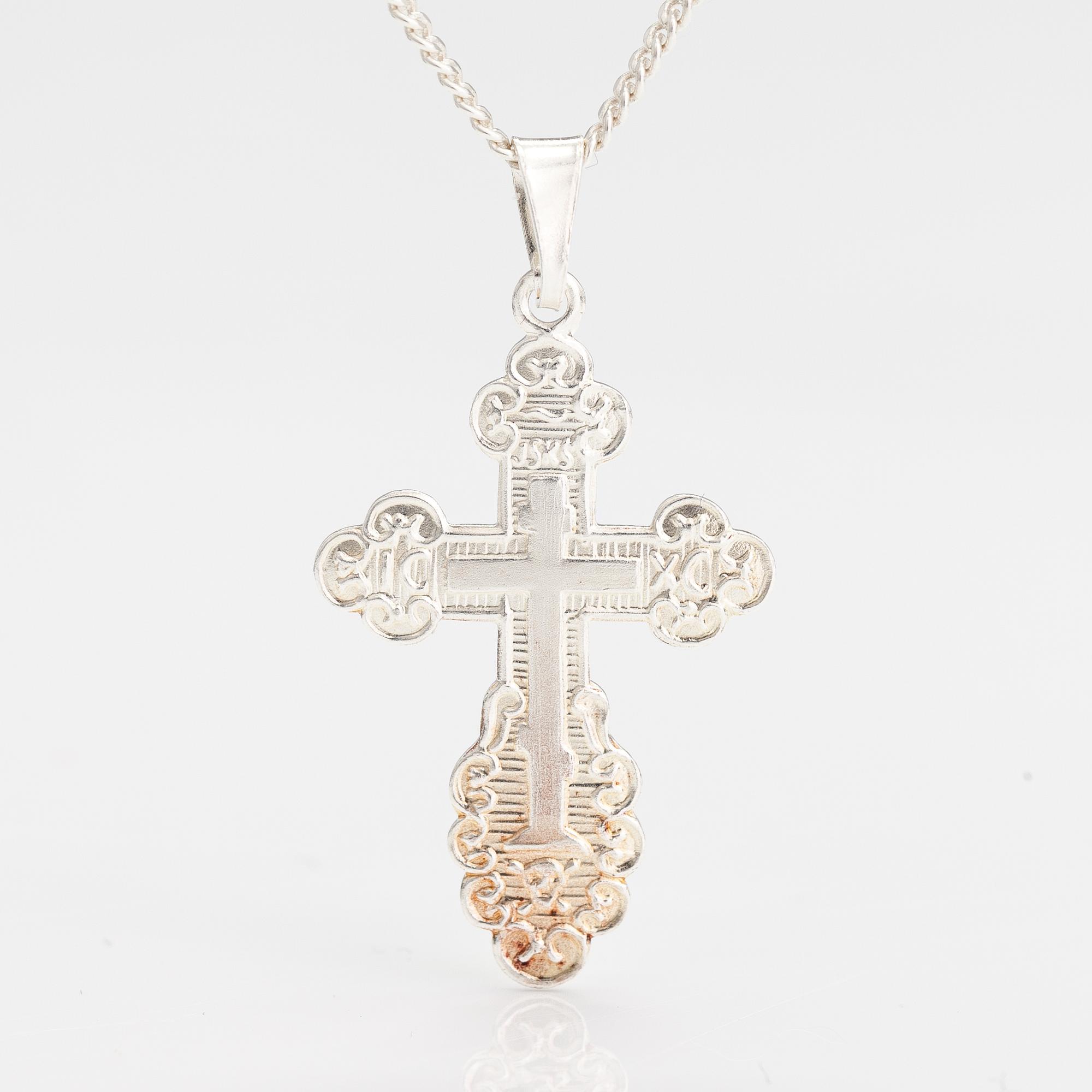 A stelring silver necklace with a cross.