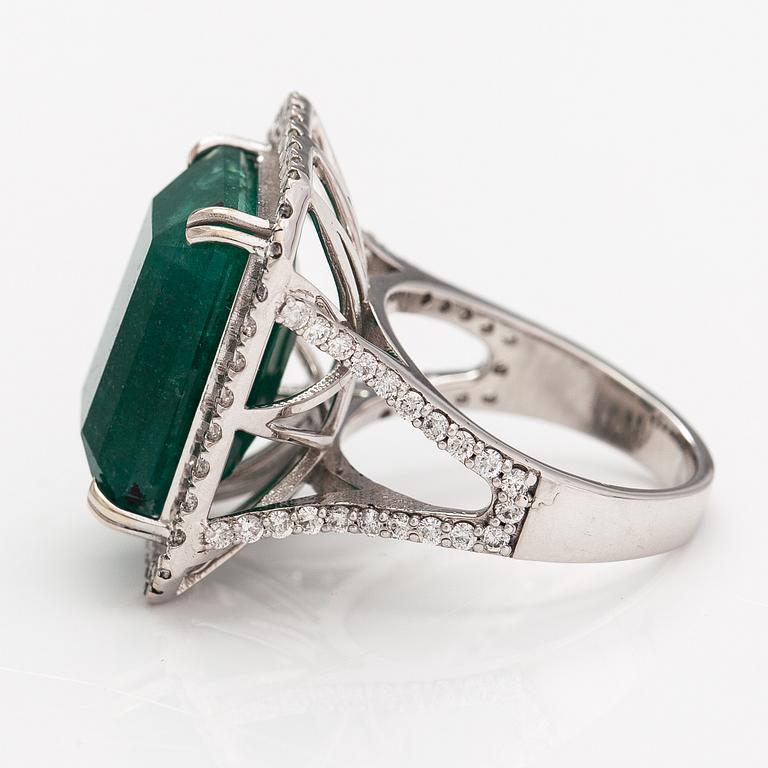 A 14K white gold ring with ca. 0.80 ct of diamonds and a emerald ca. 12.83 ct. With iGI certificate.