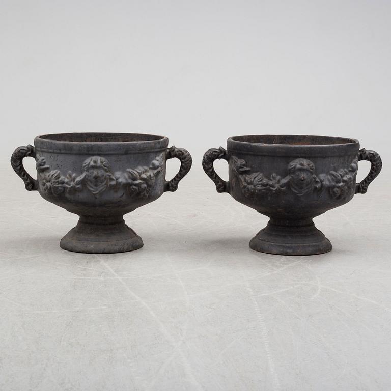 A pair of early 20th century iron garden urns.