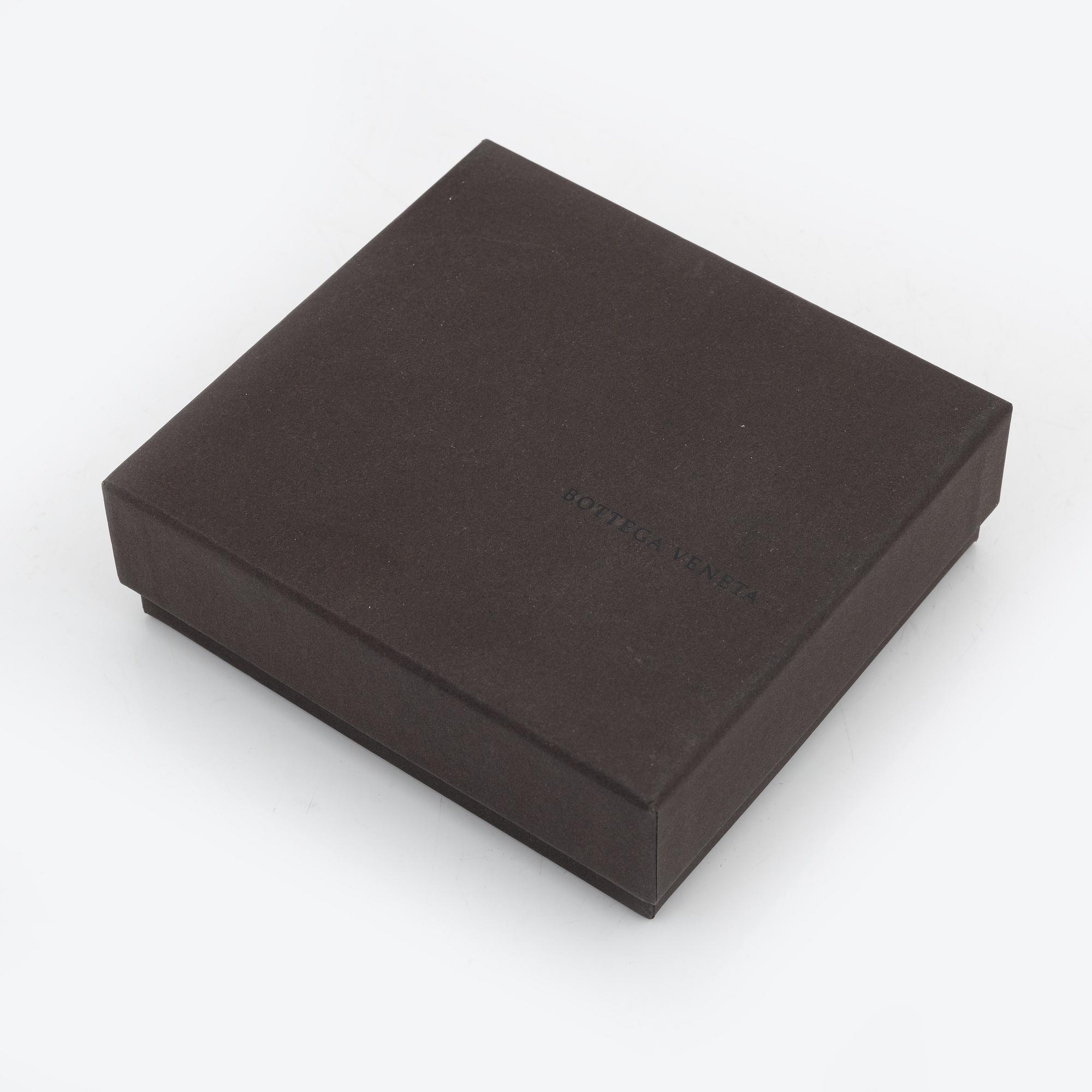 Bottega Veneta, a cerise leather wallet.