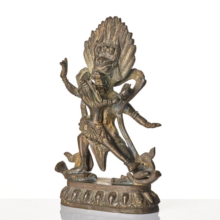 A bronze deity and a brass sacrificial bowl, Tibet, circa 1900.