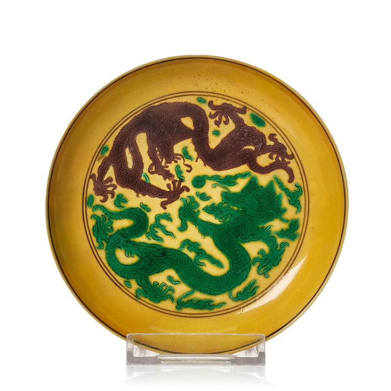 A yellow-ground green and aubergine-enamelled 'dragon' dish, late Qing dynasty, with Kangxis six character mark.