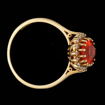 RING, 18k guld med eldopal och krans av 16 små briljantslipade diamanter, tot ca 0,16 ct. Vikt ca 4 gram.