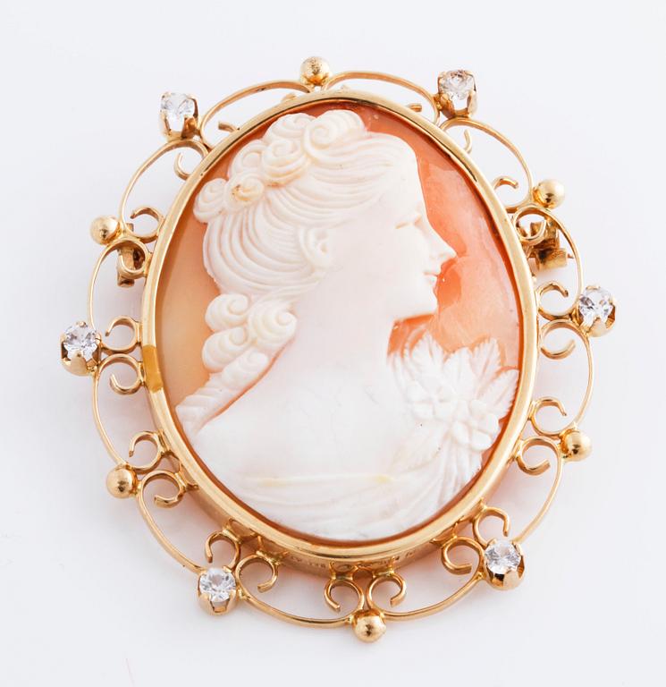 A cameo and white gemstone brooch.