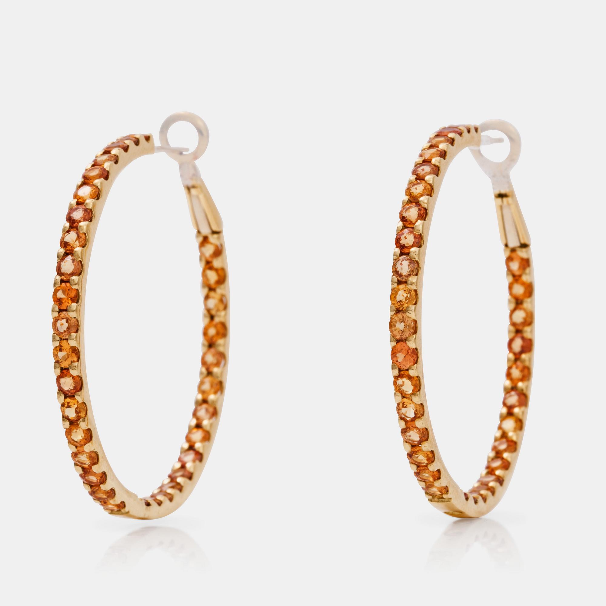 A pair of orange-yellow sapphire hoop earrings.