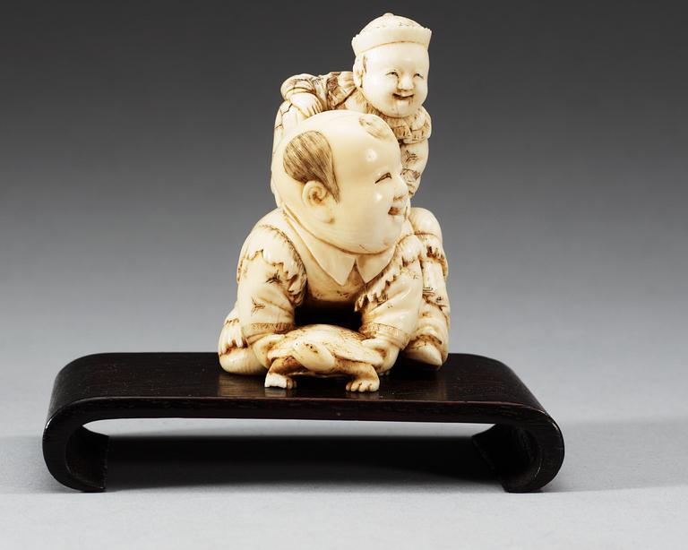 A carved ivory figure of two boys playing with at turtle, Qing dynasty.