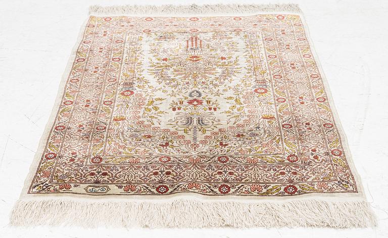 A silk Hereke rug, signed, c. 93 x 64 cm.