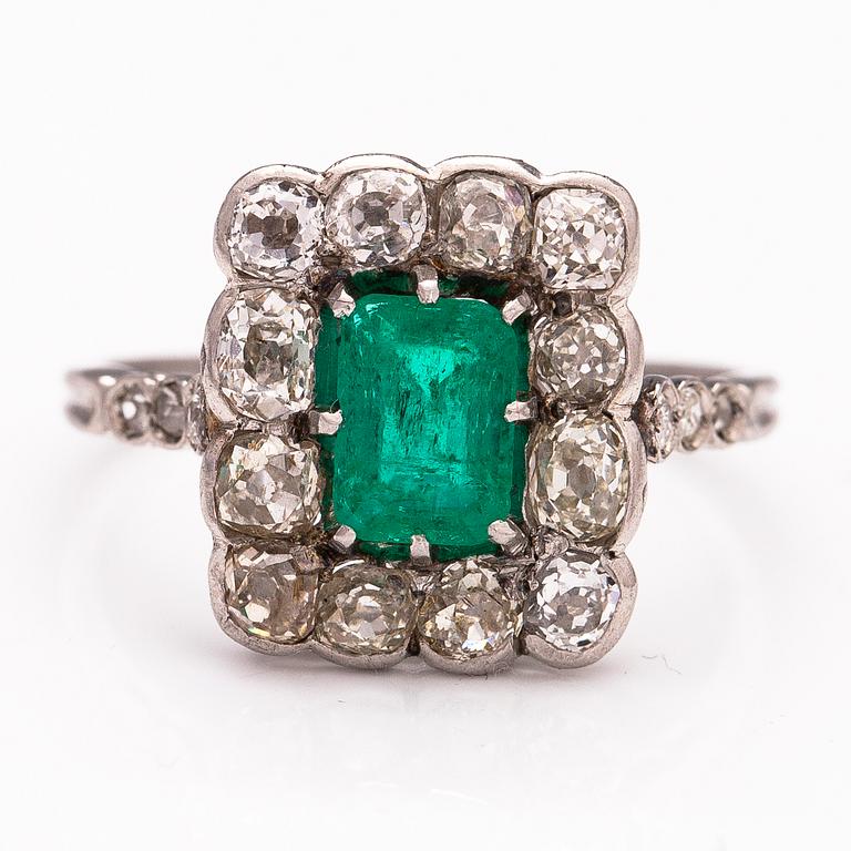 A platinum ring with an emerald ca 0.71 ct and old cut diamonds ca 1.66 ct in total.