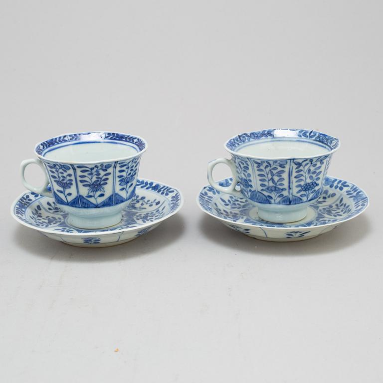 Four blue and white cups with dishes, Qing dynasty, circa 1900.