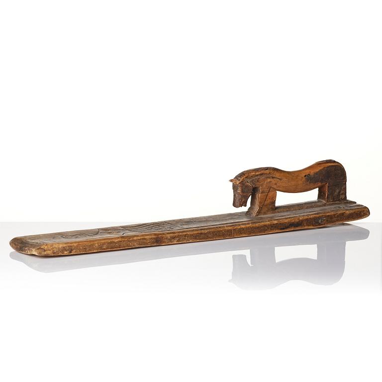 A Swedish folk art carved wringer, dated 1669.