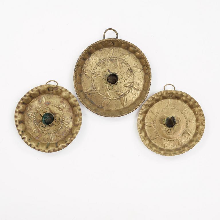 three brass candle holders from the 18th century.