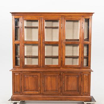 A stained walnut display cabinet from the first half of the 20th century.