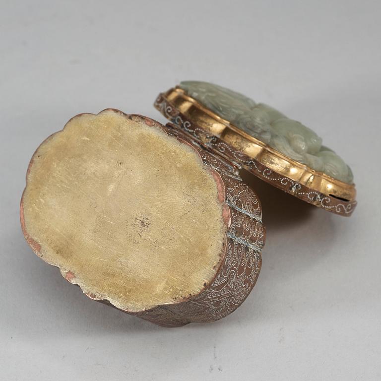 A partly gilded metal box with cover, mounted with a carved pale celadon nephrite plaque. Late Qing dynasty (1644-1912).