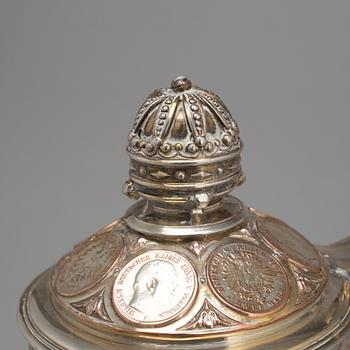 A late 19th century EPNS tankard with silver coins.