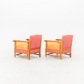 A pair of lacquered wood and rattan easy chairs from the middle of the 20th century.