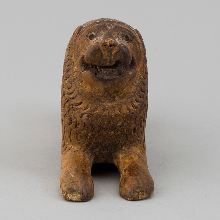 A carved wood sculpture of a lion from the 19th century.