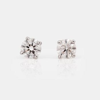 1239. A pair of brilliant-cut diamond, circa H/VVS, studs.