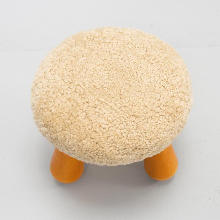 A contemporary stool with birch legs and new sheepskin upholstery.
