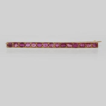 BROSCH, 18K guld med 15 fasettslipade rubiner. Vikt 4,8 gram.