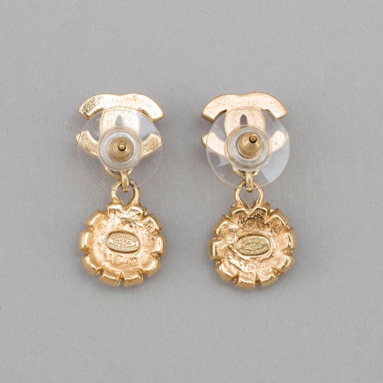 Apair of Chanel golden earrings with white and red stones, 2006.