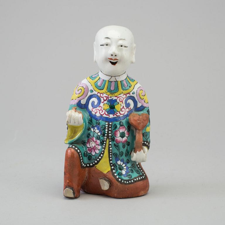 A porcelain figure of a laughing boy, Qing dynasty, 19th Century.