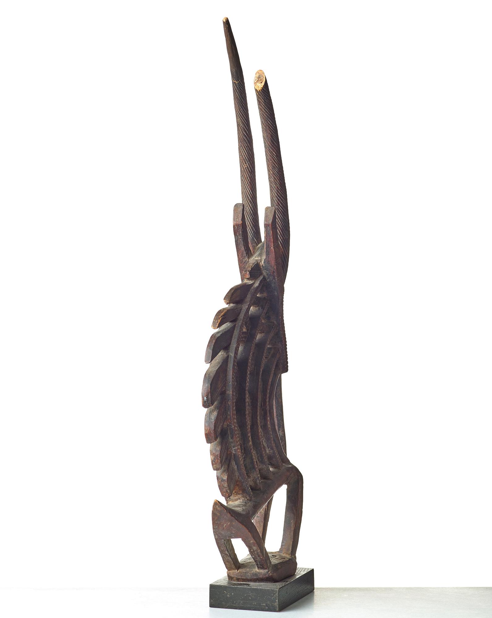 A SCULPTURE, a headdress, Tshiwara/Ciwara (stylized male antelope), wood, the Bambara tribe, Mali, h. 94 cm. On a base.