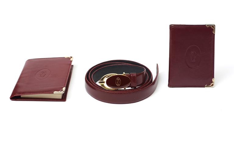 A wine red leather set consisting of briefcase, wallet, notepads and a belt by Cartier.