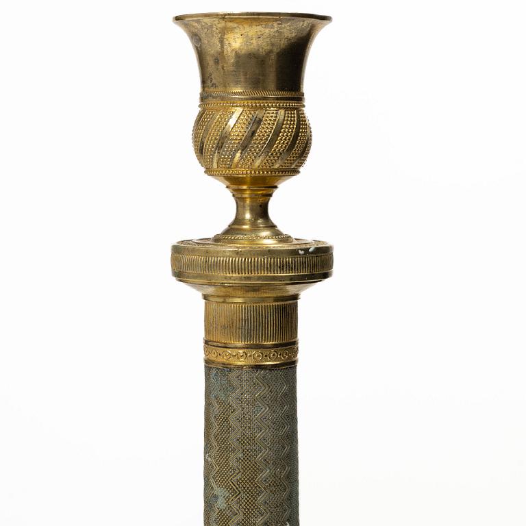 A pair of French Empire ormolu candlesticks, early 19th century.