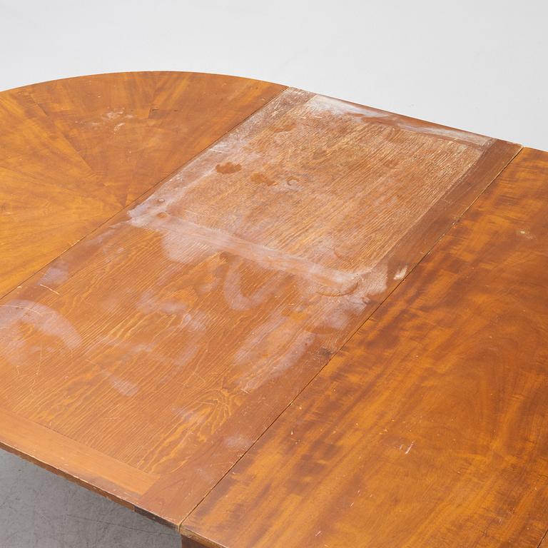 A mahogany-veneered dining table, first half of the 20th century.