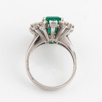 An emerald and round brilliant cut diamond ring.