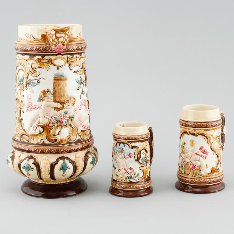 A jug and twelve beer mugs, majolica, around turn of the century 1900.