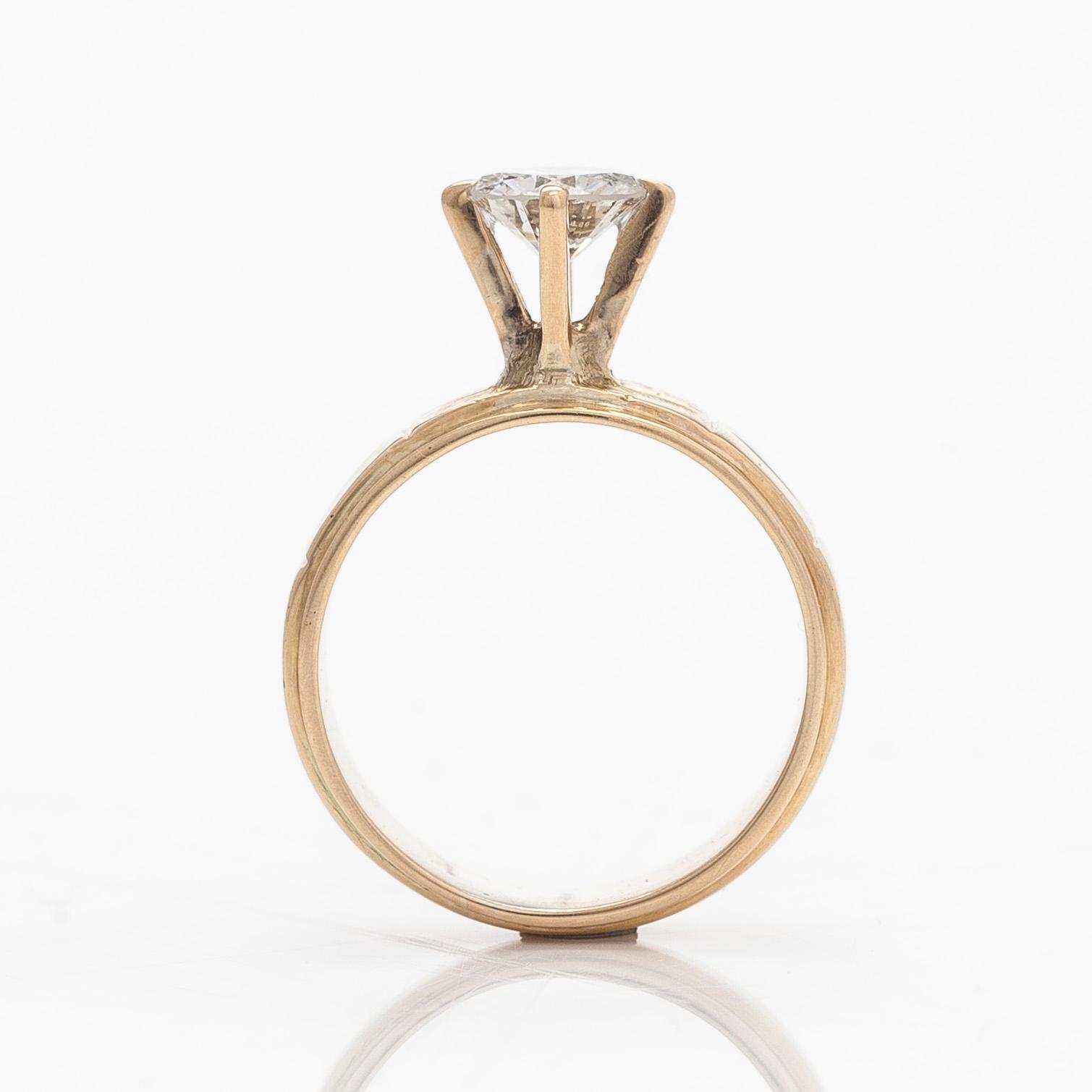 A 14K gold ring, set with a brilliant-cut diamond.