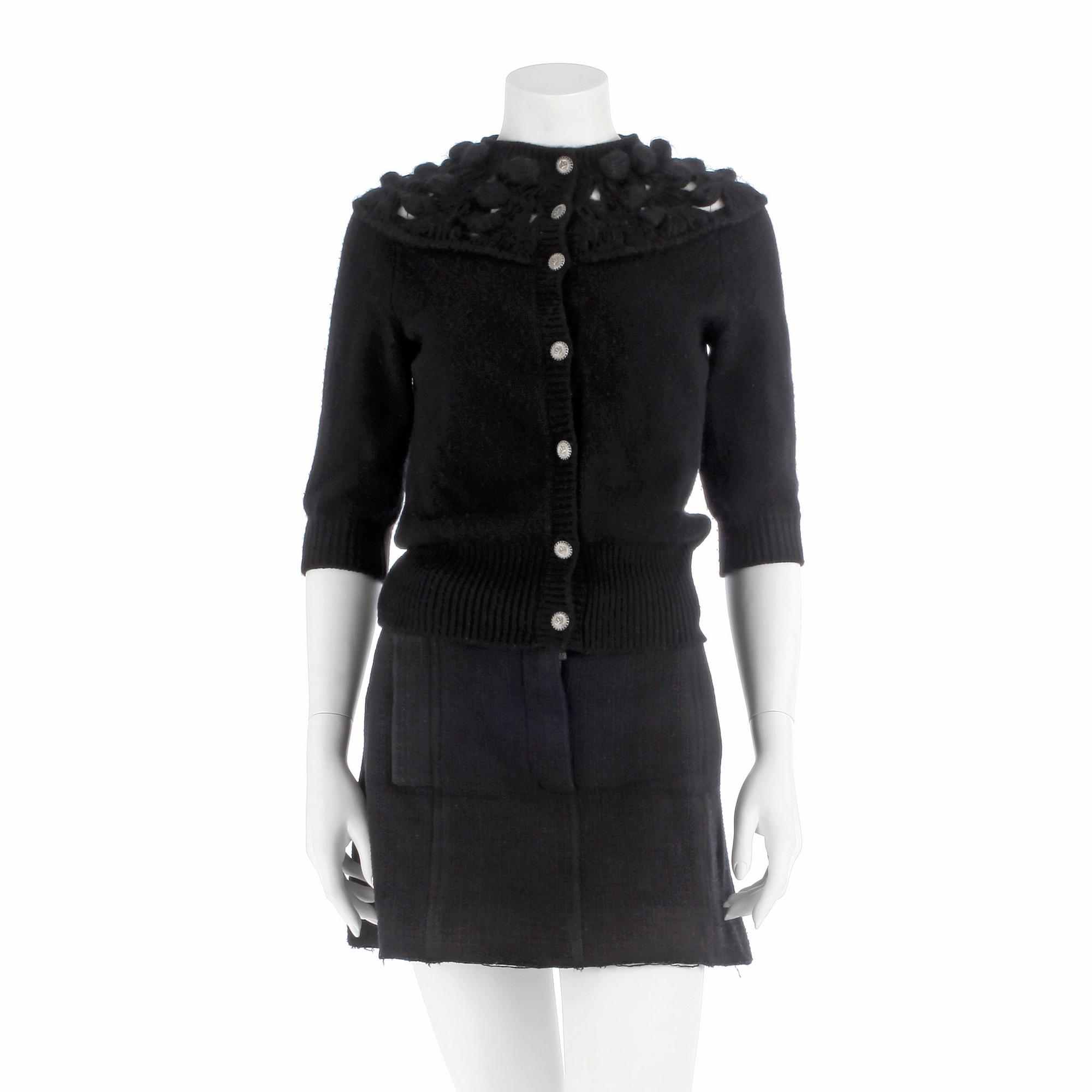 CHANEL, a black cashmere carding and a bouclé skirt.