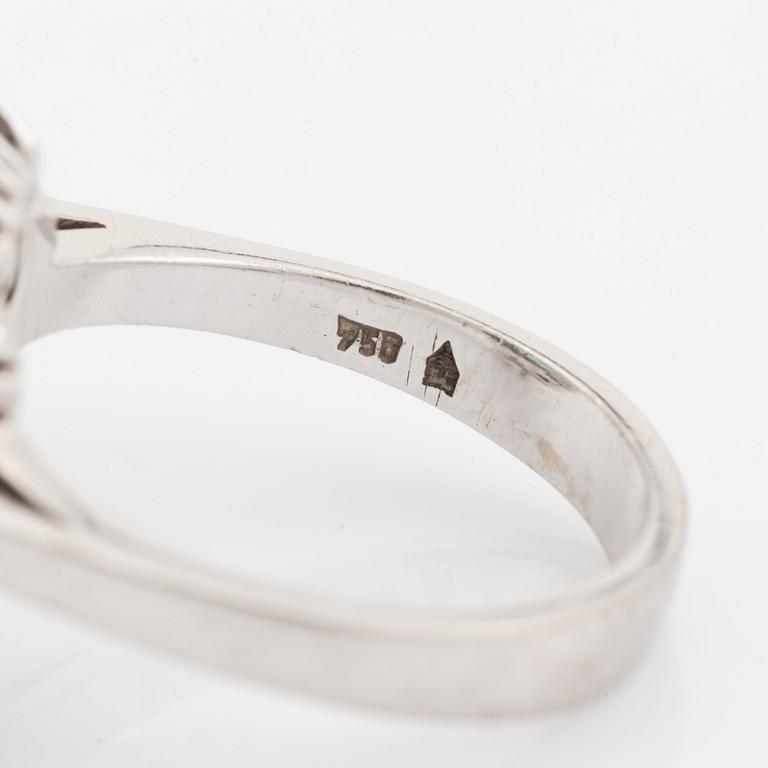 An 18K white gold ring set with a step-cut emerald.