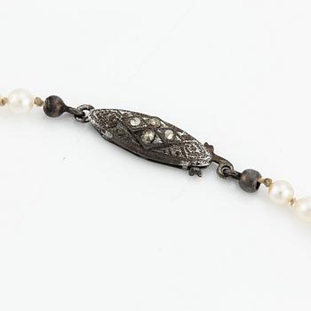 A cultured pearl necklace with a silver clasp.