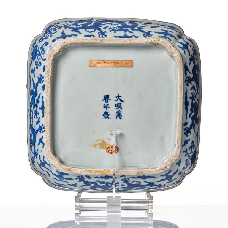 A blue and white quatrefoil dragon box with wooden cover and stand, Ming dynasty, Wanli mark and period (1573-1620).