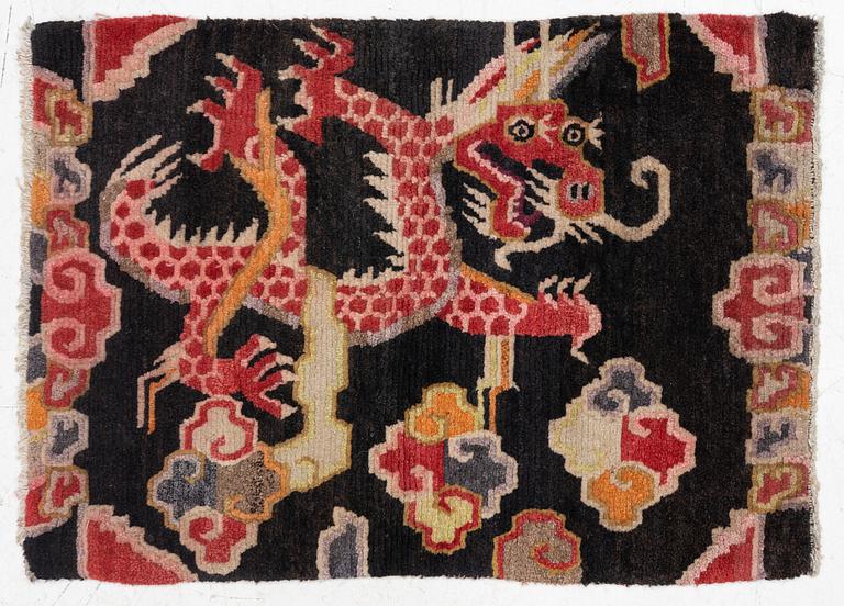 An semi-antique Tibet rug, 79 x 56 cm.