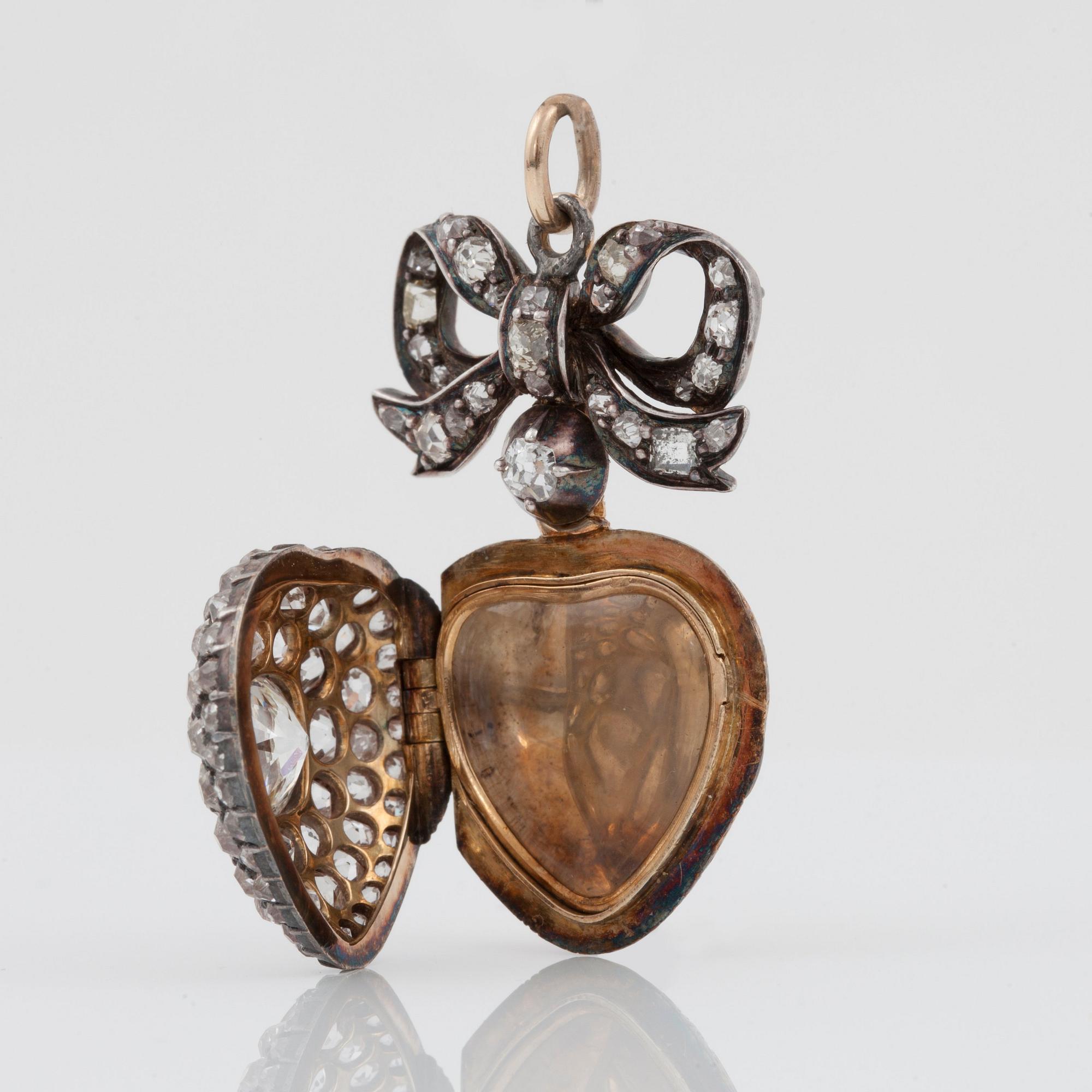 HÄNGE/MEDALJONG, hjärtformat med gammalslipade diamanter, öppningsbart. Mittsten ca 1.00 ct. 1800-talets andra hälft.
