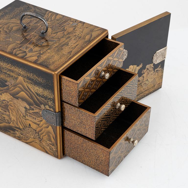 A Japanese lacquer cabinet with tree drawers behind the door, early 20th Century.