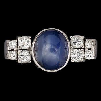 RING, cabochonslipad blå safir med briljantslipade diamanter, tot. ca 0.45 ct.