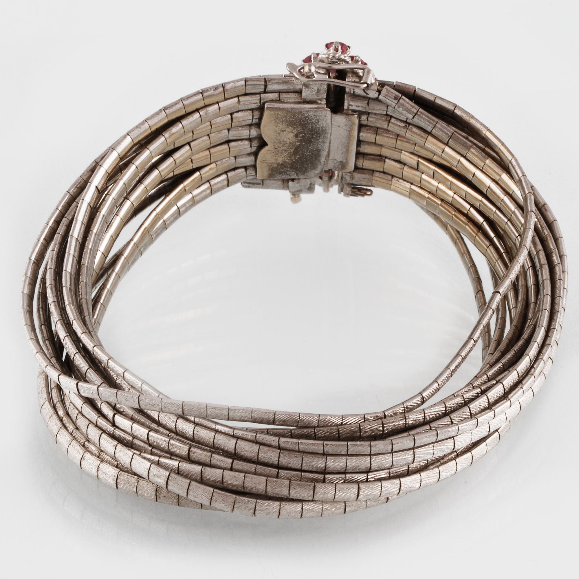 ARMBAND, 18K vitguld med 16 fasettslipade rubiner, troligtvis Italien. Vikt 96,5 gram.
