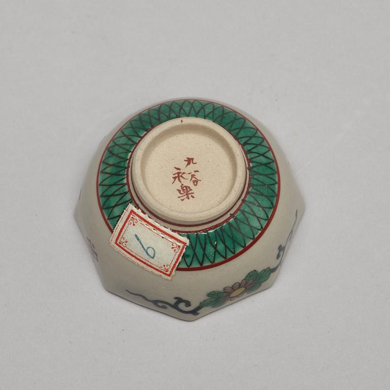 A set of two Japanese figures and a set of six cups in a wooden box, early 20th Century.