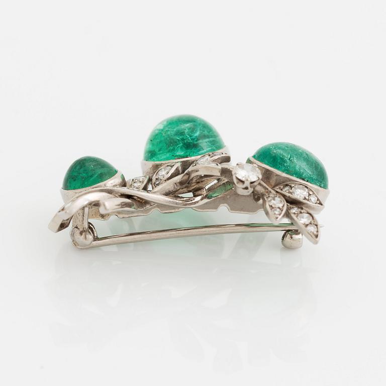 A WA Bolin brooch in 18K white gold set with a cabochon-cut emerald and eight-cut diamonds.