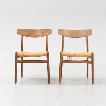 Hans J Wegner, a pair of model 'CH-23' oak and rattan chairs, Carl Hansen & Son, Odense, Denmark.