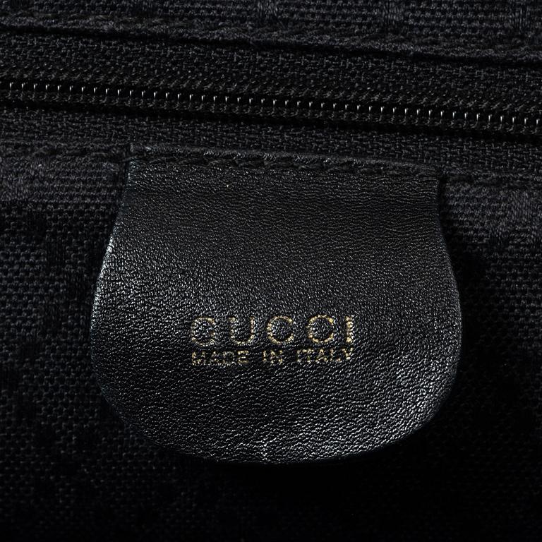 Gucci, A black leather backpack.