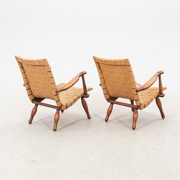 A pair of Swedish Modern pine and saddle-girth easy chairs from the 1940's.