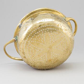 A 19th century brass colander.