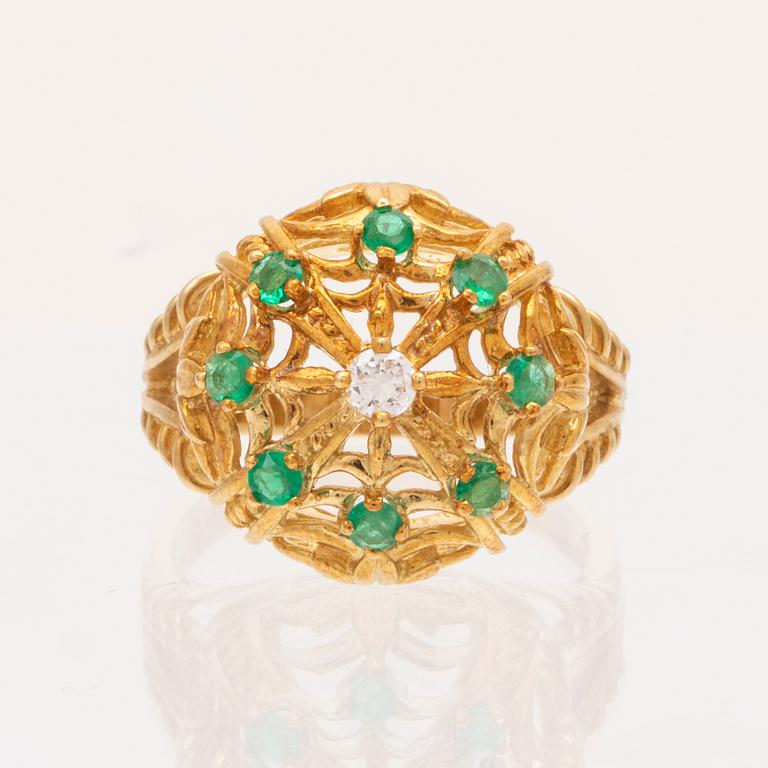 An 18K gold ring set with a round brilliant cut diamond and round single cut emeralds by Franklin Mint 1980.