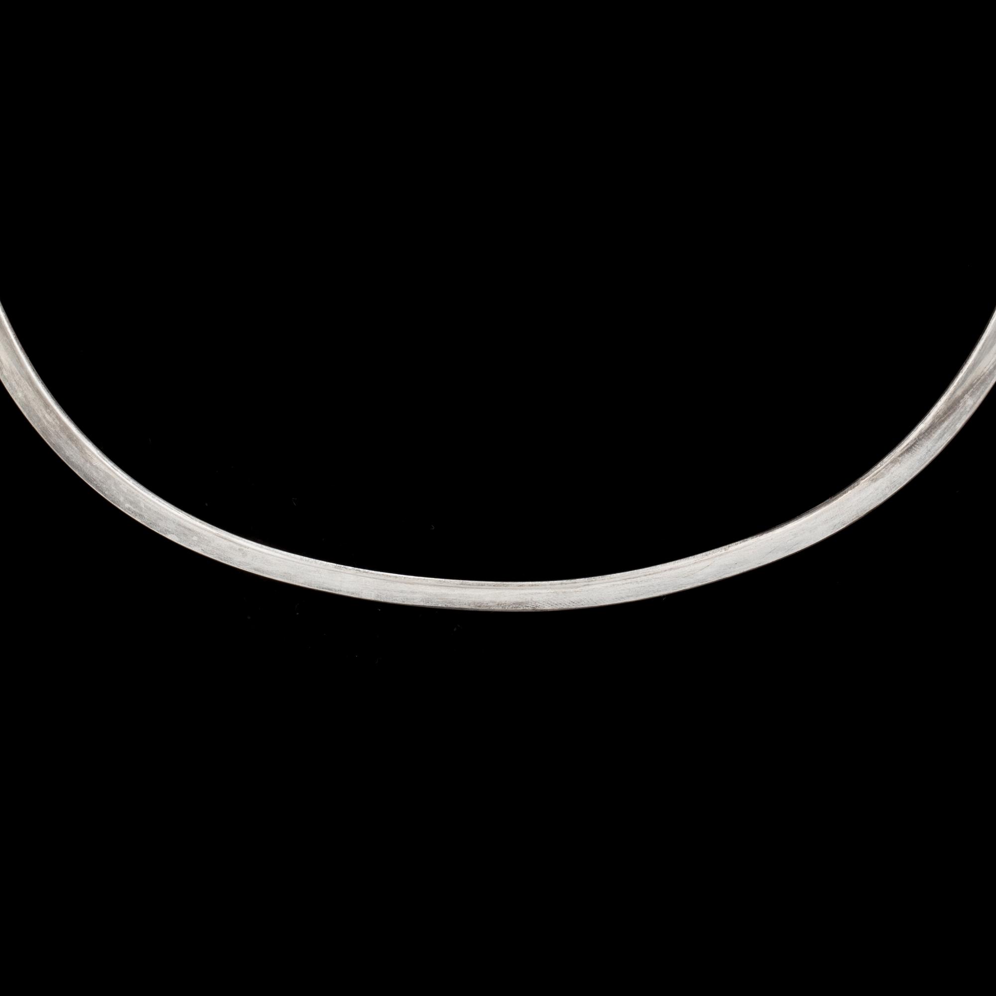 A silver, 'Dew Drop' neckring by VIVIANNA TORUN BÜLOW-HÜBE for Georg Jensen, Denmark, desgined 1955.